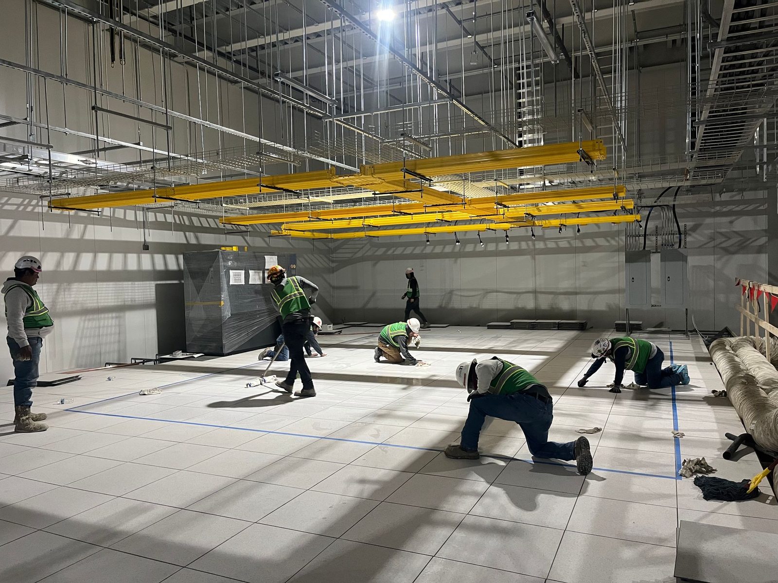 Crew setting access floor under the overhead fiber raceway