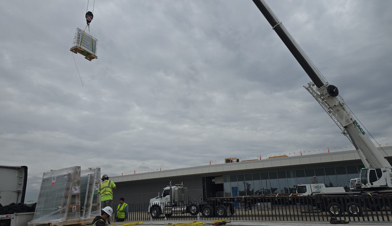 Rigging crew lifting a skylight crate off the truck