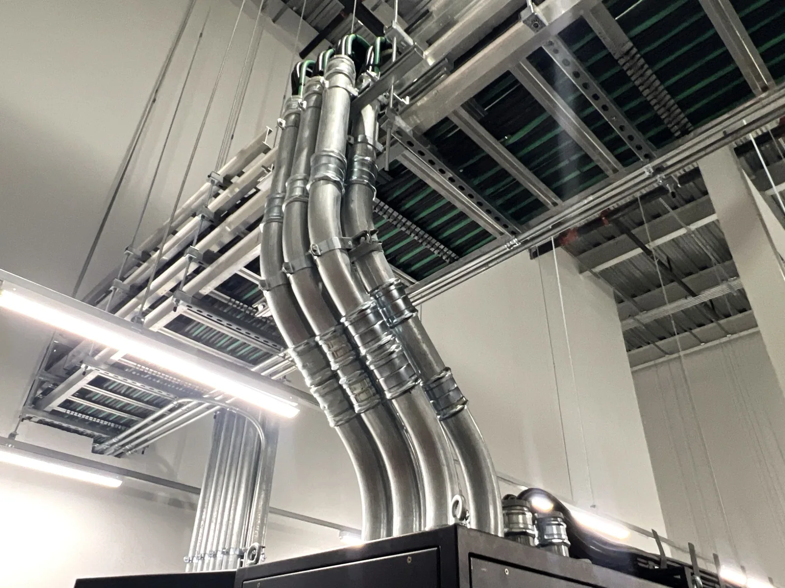 Conduit drops from overhead tray to equipment