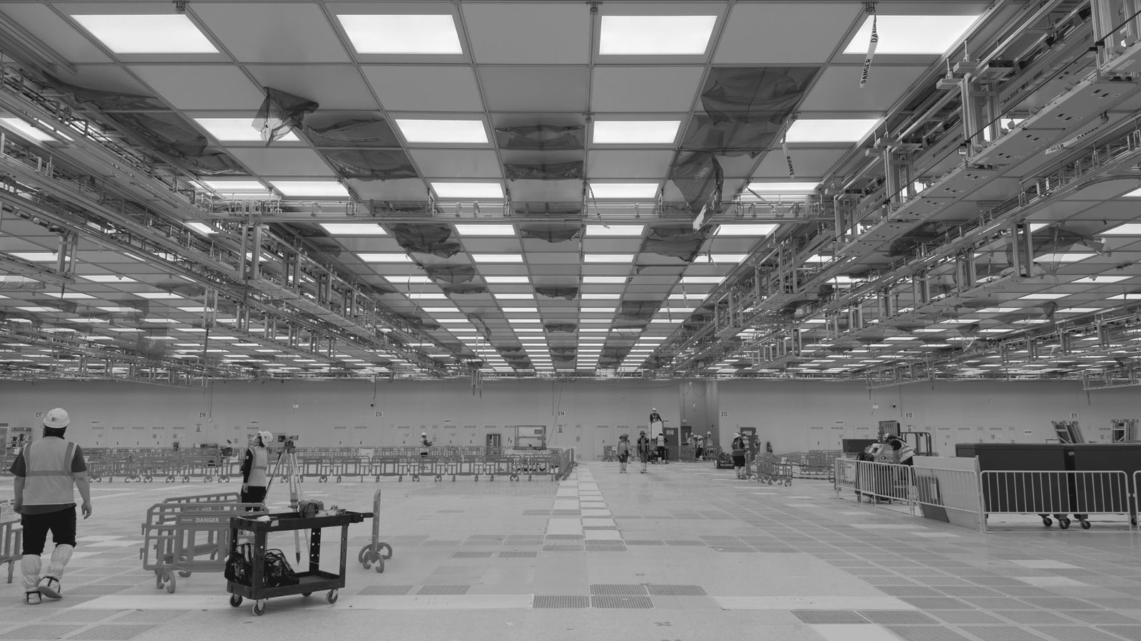 Concept video, 15-second loop: from a real cleanroom photo to the leveled floor, anchor bolts and threaded rods, the ceiling grid and FFUs, AMHS rails hung from the main tees, and tool power with controls and communications from under the access floor